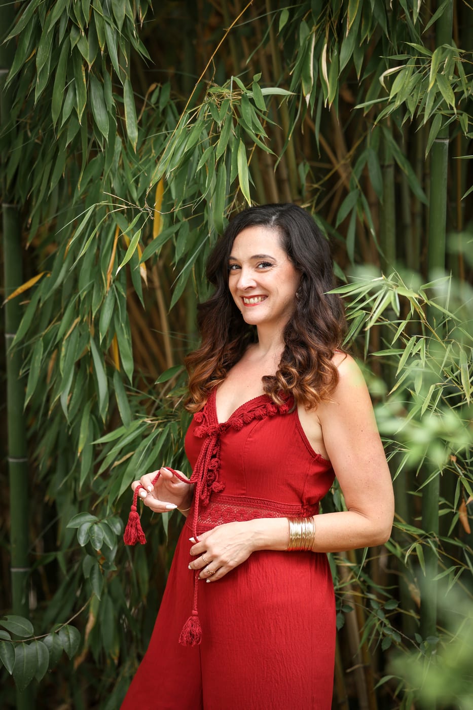 Portrait de Charlotte Maturano en robe rouge devant des bambous